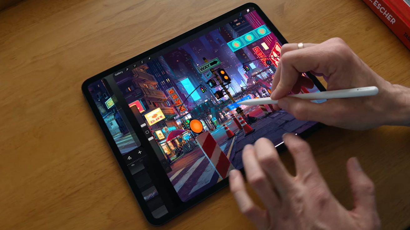 Ruka držící Apple Pencil Pro při kreslení na iPad Pro
