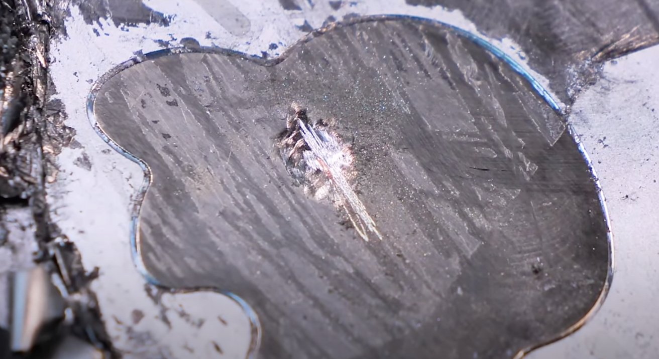 Logo Apple, poškrábané, aby bylo vidět měď [Youtube/Phone Repair Guru]