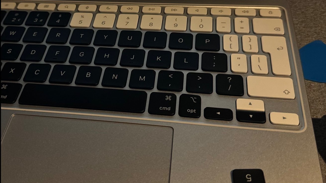 Zblízka bílé hliníkové magické klávesnice s bílými a černými klávesami